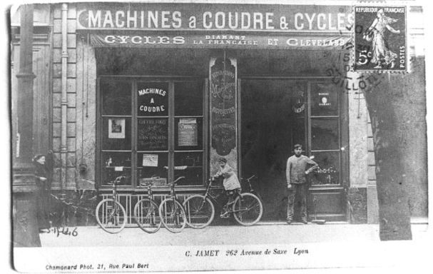 Devanture du magasin Jamet (machines à coudre et cycles): reproduction d'une carte postale (vers 1910), tirage photographique NB par Jean-Paul Tabey (s.d., cote : 1PH/4668 repro. commerciale interdite)