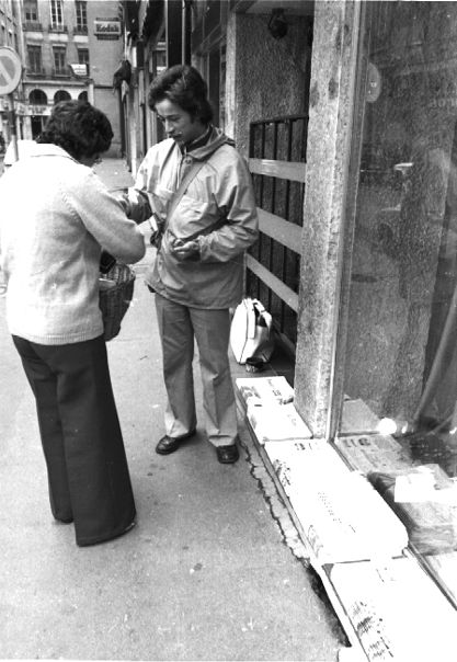 Vendeur de journaux dans la rue le dimanche matin : tirage photographique NB par Jean-Paul Tabey (1972, cote : 1PH/5157 repro. commerciale interdite)