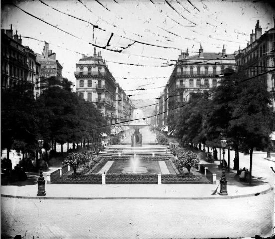 Place Impériale (actuellement place de la République), à Lyon, avec la fontaine installée par la Compagnie des eaux en 1856 : vue en direction du nord : photo négative NB sur plaque de verre (1863, cote : 3PH/572)