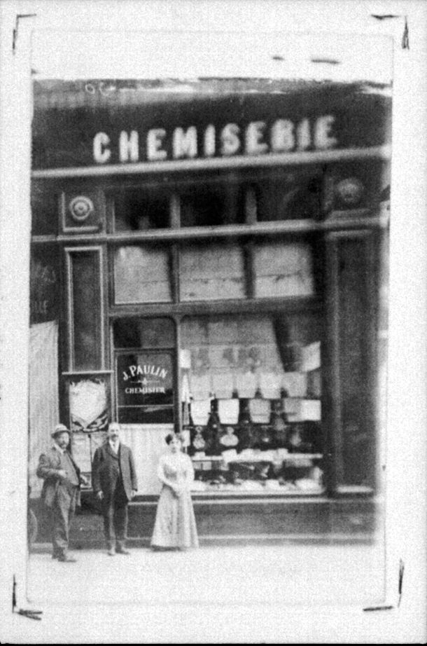 Commerçants et employés devant la vitrine d'une chemiserie : photo négative NB sur film souple par Emile Poix (vers 1900, cote : 8PH/3349)