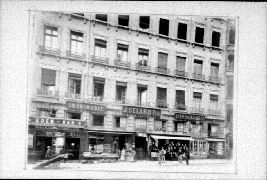 Façades d'immeubles non localisés, au rez-de-chaussée vitrines de commerces : photo négative NB sur film souple par Emile Poix (vers 1900, cote : 8PH/3364)