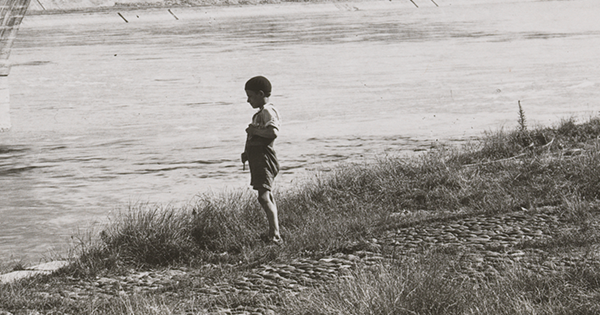 Photo d'un enfant seul au bord d'une rivière