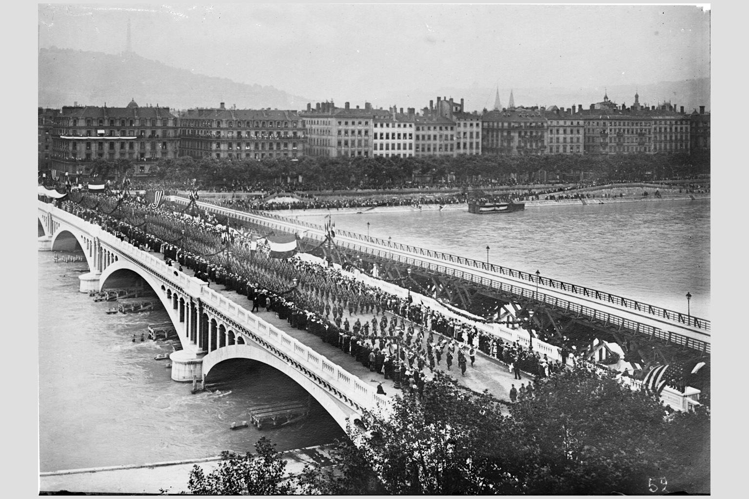 Photographie sur plaque de verre du défilé militaire sur le pont Wilson, avec les troupes américaines au 1er plan, 14 juillet 1918, fonds du service municipal de la voirie - 15PH/1/616