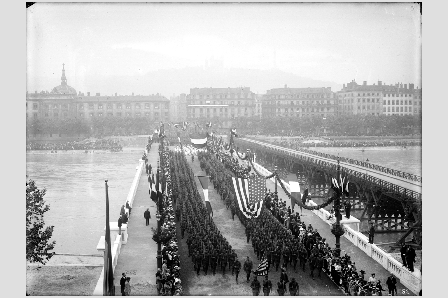 Photographie sur plaque de verre du défilé militaire sur le pont Wilson, avec les troupes américaines au 1er plan, 14 juillet 1918, fonds du service municipal de la voirie - 15PH/1/783