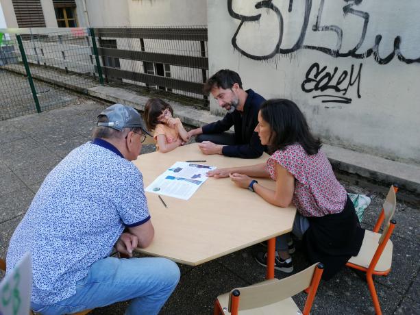 Groupe d'adultes échangeant autour d'une table 