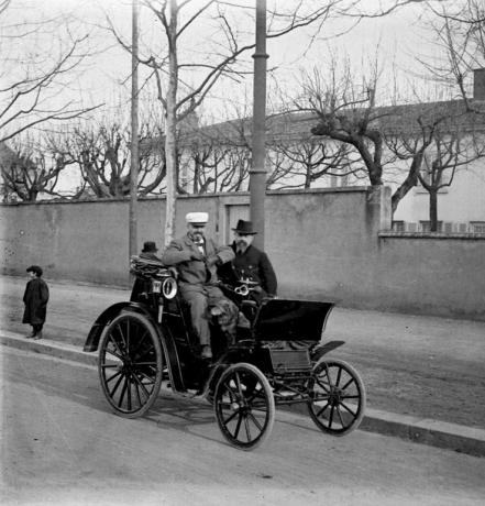 Départ d'une course de tricycles à pétrole et de voitures automobiles, automobile avec passagers : photo. NB (v. 1900, cote 10PH/25)