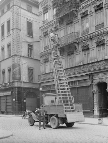 Éclairage public, entretien des luminaires à l'angle des rues Neuve et de l'hôtel de ville (actuellement rue E. Herriot) : photo. jour NB anonyme (v. 1920-1930, cote 15PH/1/332)