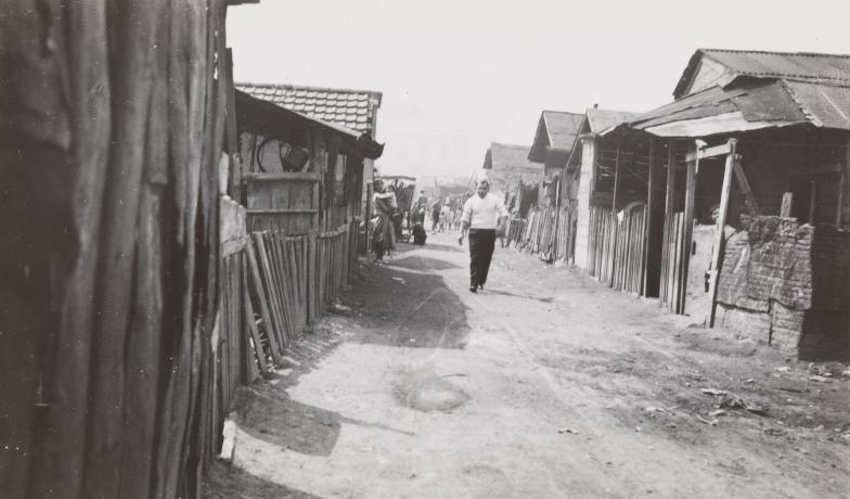 Quartier de Gerland, coin de la colonie espagnole, individu marchant dans la rue : photo. NB (1934, cote 1PH/8344)