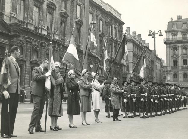 Cérémonie militaire place Bellecour avec des femmes de l'association et entraide des veuves et orphelins de guerre section du Rhône  : tirage photo. NB (sans date, cote 231II/26)
